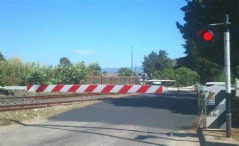 Resta appeso per venti minuti alla sbarra del passaggio a livello